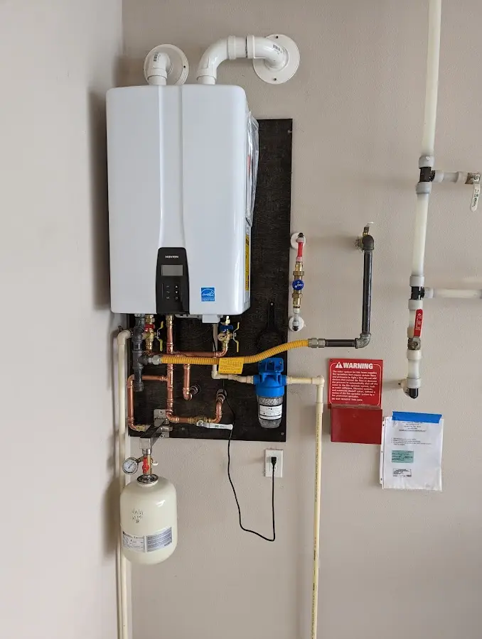 Professional plumber installing copper piping in a Milford home